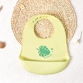 Light green silicone baby bib with leaf pattern and large food catcher pocket - Palm Leaf