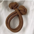 Brown elastic dual-strand braided hair tie with a durable knot design on fabric - Brown