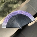 Purple-black gradient folding fan with pink flowers and hollowed black ribs on stone - Hollow Butterfly Purple Blue