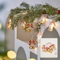 Christmas LED string lights with yellow bells, red bows and warm bokeh lighting effects - Iron Painted Bell