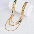 Detail view of gold layered necklace with flat snake chain and green beads on a white stand - Malachite Green