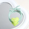 Light green elastic hair tie with glossy heart ornament on a decorative mirror - Heart / Green