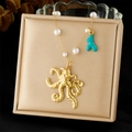 Dettaglio della collana con ciondolo a polpo dorato, corallo turchese e perle bianche - Stile Polpo (N3589)