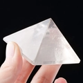 Handheld transparent natural white crystal pyramid with smooth finish on black background - 8.5cm