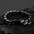 Detail van een 12mm zwarte Cuban link armband met zirkonia op een donker stenen oppervlak - 23CM / Zwart
