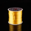 Yellow crystal stretch elastic cord on white spool for DIY beaded jewelry crafting - Yellow