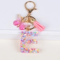 Detail of resin letter E keychain with colorful sequins, pink butterfly and tassel charm - Letter E