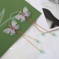 Détail de longues boucles d'oreilles dorées avec papillons colorés et gouttes d'eau - Style Papillon Gland Peint Forêt