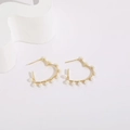 Gros plan détaillé des boucles d'oreilles en forme de cœur doré ornées de perles - Cœur