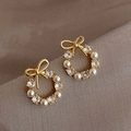 Detail of bowknot pearl wreath earrings in gold finish with sparkling zircons - Gold