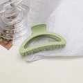 Dettaglio di una pinza per capelli verde chiaro opaco su fondo bianco testurizzato - Semicerchio / Verde Fagiolo