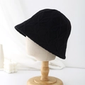 Close-up of black knitted bucket hat with diamond lattice texture on wooden mannequin - Black