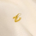 Makroaufnahme eines goldenen Z-Anhängers in Schreibschrift auf Seidenstoff - Buchstabe V / 0.8cm*1cm
