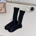 Classic black ribbed cotton ballet style mid-calf socks shown in a minimalist setting - Black