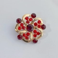 Gold swirl flower brooch with deep red rhinestones and polished alloy finish - Red Vortex Flower