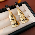 Detail of fan-shaped drop earrings with branch pattern and beads on a jewelry box liner - Silver Earring Post - Gold - Black