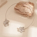 Detailed view of silver flower choker with textured petals on natural stone background - Silver
