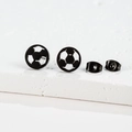 Detail of black soccer stud earrings with hollow design on white stone display - Football / Black