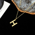 Golden H letter pendant necklace with pavé diamonds and hammered metal texture - Letter H