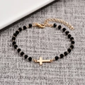 Bracciale minimalista con perline nere sfaccettate e ciondolo a croce placcato oro - Croce