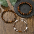 Tiger eye stone bead bracelets and silver cuboid charm wristbands on a dark wood table - 3 Pcs Set Tiger Eye With Metal Spacers Lobster Clasp