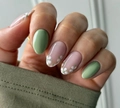 Detalle de uñas postizas almendradas en verde liso con diseños de flores blancas - Estilo floral fresco verde con pegamento de gelatina amarillo (CW680)
