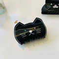 Close-up of black acetate cat hair claw with sparkling rhinestone eyes and white whiskers - Black Pink Blue Diamond Eye Cat