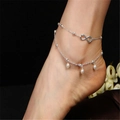 Silver infinity double-layer anklet with white faux pearl charms on a black background - Silver Infinity Pearl Style