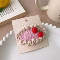 Détail d'une barrette à cheveux cerise faite main sur une assiette décorative en porcelaine - Cerise en dentelle rose