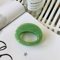 Macro detail of glossy grass green oval hair claw clip with a thick resin butterfly hinge - Approx 7cm / Leaf Green