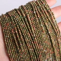 Hand holding strands of 2mm green and reddish-brown unakite natural stone beads - Unakite