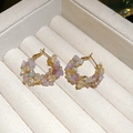 Dettaglio di orecchini a cerchio dorati con cristalli pastello e piccole perle lucide - Perno in argento - Oro - Viola