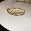 Macro shot of 18k gold plated snake-shaped cuff featuring green gems and pavé zircon stones - 1# Golden Waterdrop Crossover (Real Gold Plated)