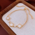 Detailed macro view of gold-plated clover bracelet with zircon inlay and adjustable slide clasp - Gold