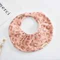 Detail eines weichen Baby-Lätzchens aus Baumwolle mit Rosa Leopardenmuster und Rüschen - Oval / Kirschrosa