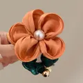 Dettaglio ravvicinato dell'elastico floreale fatto a mano con fiore di raso arancione e perla - Scrunchie Fiore Arancione
