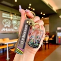 Detailed close-up of a liquid quicksand keychain with star sequins and superhero wrist strap - Black Luminous Bubble Bead Coke Can