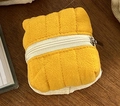 Quilted yellow fabric headphone storage pouch with white zipper on wooden desk - Lemon Yellow