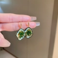 Elegante Herzohrringe mit Goldrand, hellgrüner Emaille und dunkelgrüner Blütenmitte - Grüner Blumenhaken Stil