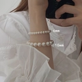 Detail showing 6mm and 10mm cream white pearl stretch bracelets worn together - 6+10mm Pearl Bracelet Set