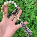 Close-up of beaded wristlet keychain with leopard print tassel held outdoors - Leopard Printed Tassel Brown Black Beaded (款19)