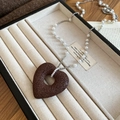 Dettaglio del ciondolo a cuore in pietra con perle e catena d'argento nel portagioie - Ciondolo a Cuore in Pietra Lavica Con Perla Sintetica e Catena d'Argento