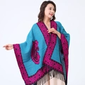 Blue paisley shawl with pink patterns and black tassels shown on a model - Blue/Border Paisley