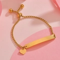 Close-up of golden box chain bracelet featuring an engravable bar and a heart charm - Gold Heart