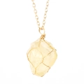Detail of a raw yellow crystal pendant with gold wire-wrapped design on a slim chain - Gold + Citrine