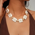 Detalle de un collar de cadena vintage dorado con esmalte blanco y cristales brillantes - Collar / Blanco