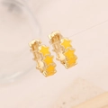 Detail of gold star drop earrings featuring three yellow enamel stars hanging on a line - Khaki/Earth Yellow