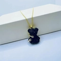 Golden necklace featuring a cute black crystal bear pendant on white pedestal - Necklace / Black
