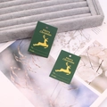 Close-up of green and gold Christmas gift tags with Merry Christmas text on velvet - Green No.1 (Reindeer)