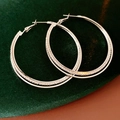 Close-up of silver double intertwined oversized hoop earrings with sparkling rhinestones - Silver (925 Sterling Silver Earring Post)
